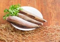 Uncooked Alaska pollock carcasses on wooden surface with fishing