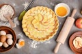 Uncooked apple pie with ingredients on table