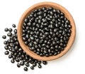 Uncooked black beans in the wooden plate, isolated on the white background, top view