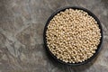 Uncooked Chickpeas in Rustic Black Bowl over Stone Background Top View