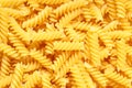 Uncooked close up yellow fusilli pasta background. Spiral raw italian pasta. rotini Royalty Free Stock Photo