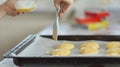 Uncooked dough rolls on the tray with egg yolk