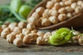 Uncooked dried chickpeas in wooden spoon with raw green chickpea pod plant on wooden table Royalty Free Stock Photo