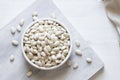 Uncooked dried white haricot beans in bowl or spoon on table Royalty Free Stock Photo