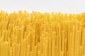 Uncooked durum fettuccine pasta on white background. Raw spaghetti or noodles
