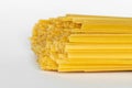 Uncooked durum fettuccine pasta on white background. Raw spaghetti or noodles