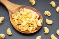 Uncooked elbows pasta in wooden spoon Royalty Free Stock Photo