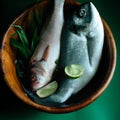 Uncooked fish with lime and herbs in a wooden bowl