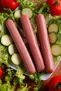 Uncooked frankfurters with fresh vegetables Royalty Free Stock Photo