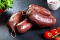 Uncooked fresh blood sausage with parsley and tomato. raw pork with cherry tomatoes Royalty Free Stock Photo
