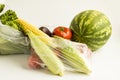 Uncooked,fresh vegetables and fruits in plastic shopping bags on white background with copy space. Royalty Free Stock Photo