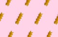 Uncooked fusilli pasta isolated on pink seamless background. Itallian spiral pasta close-up on pink seamless pattern