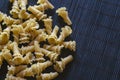 Uncooked Gigli or campanelle pasta On a dark bamboo napkin