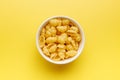 Uncooked gnocchi pasta. Raw italian pasta in bowl on yellow background