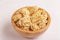 Uncooked instant noodles in wooden bowl on white marble background. Royalty Free Stock Photo