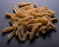 Uncooked Italian Casarecce pasta made from organic durum wheat semolina on natural stone. Macaroni product.