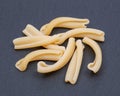 Uncooked Italian Casarecce pasta made from organic durum wheat semolina on natural stone. Macaroni product.