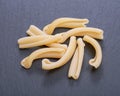 Uncooked Italian Casarecce pasta made from organic durum wheat semolina on natural stone. Macaroni product.