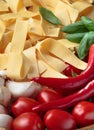 Uncooked Italian noodles with garlic, basil, tomatoes cherry and Royalty Free Stock Photo