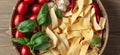 Uncooked Italian noodles with garlic, basil, tomatoes cherry and Royalty Free Stock Photo