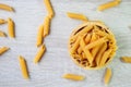 Uncooked italian pasta penne on wooden cup