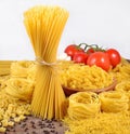 Uncooked Italian pasta, ripe tomatoes branch and black pepper on Royalty Free Stock Photo