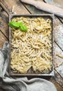 Uncooked Italian pasta in wooden tray over shabby background Royalty Free Stock Photo