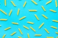 Uncooked Italian Penne Pasta Scattered on Blue Background. Food Pattern. Bright Vibrant Yellow Color.