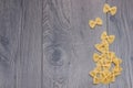 Uncooked italian raw pasta farfalle on the wooden background. Top view, flat lay. Royalty Free Stock Photo