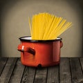 Uncooked Italian spaghetti in a red pot