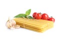 Uncooked lasagna sheets with cherry tomatoes, garlic and basil isolated