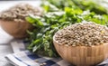 Uncooked lentils in wooden bowles with parsley herbs on kitchen table