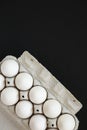 Uncooked Organic White Eggs in a paper box on a black surface, top view. Flat lay, overhead, from above. Space for text Royalty Free Stock Photo