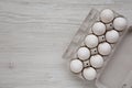 Uncooked Organic White Eggs in a paper box on a white wooden surface, top view. Flat lay, overhead, from above. Copy space Royalty Free Stock Photo