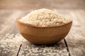 Uncooked parboiled rice in a bowl on wooden table Royalty Free Stock Photo