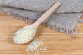 Uncooked parboiled rice in the wooden spoon on wooden surface