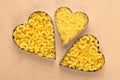 Uncooked pasta on brown paper. Raw macaroni in the shape of a heart. A heap of yellow noodles Royalty Free Stock Photo