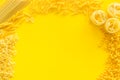 Uncooked pasta frame for italian food on yellow table background top view copyspace Royalty Free Stock Photo