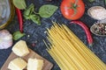 Uncooked pasta and products on black background. dry spaghetti with vegetables, herbs and cheese on a wooden table. top Royalty Free Stock Photo
