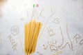 Uncooked pasta spaghetti macaroni and italian flag on floured white background. Food travel italian cuisine concept