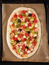 Uncooked pizza prepared for baking on a sheet for baking. Italian food. Top view