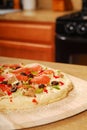 Uncooked pizza on a wooden peel Royalty Free Stock Photo