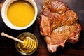 uncooked pork chop with a bowl of honey mustard sauce next to it Royalty Free Stock Photo