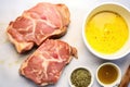 uncooked pork chop with a bowl of honey mustard sauce next to it Royalty Free Stock Photo