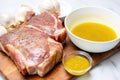 uncooked pork chop with a bowl of honey mustard sauce next to it Royalty Free Stock Photo