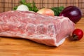Uncooked pork loin against the fresh vegetables on cutting board Royalty Free Stock Photo