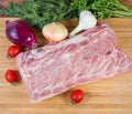 Uncooked pork loin among vegetables on cutting board, top view Royalty Free Stock Photo