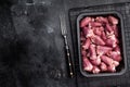 Uncooked poultry hearts in container, dark backdrop accentuates rich pink hue Royalty Free Stock Photo