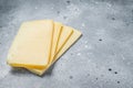 Uncooked Raclette Swiss cheese slices. Gray background. Top view. Copy space