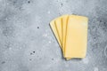 Uncooked Raclette Swiss cheese slices. Gray background. Top view. Copy space